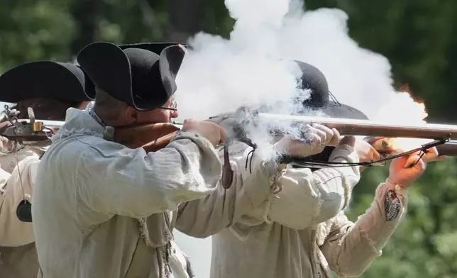 Re-enactors fire a volley with their flintlock muskets during a Revolutionary War event in Halifax, N.C., on April 11, 2026. (AP Photo/Allen G. Breed)