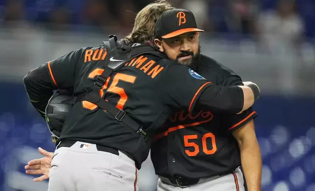 Baltimore Orioles closing pitcher Rico Garcia (50) gets a hug from catcher Adley Rutschman (35) after defeating the Miami Marlins during in a baseball game, Tuesday, May 5, 2026, in Miami. (AP Photo/Rebecca Blackwell)