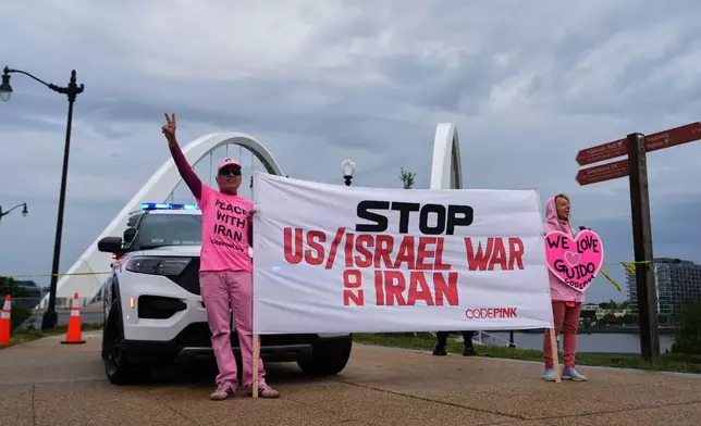 Supporters of Guido Reichstadter, 45, are seen near the Frederick Douglass Bridge, Wednesday, May 6, 2026 in Washington. Reichstadter has come down, after his 6-day protest. (AP Photo/Julia Demaree-Nikhinson)