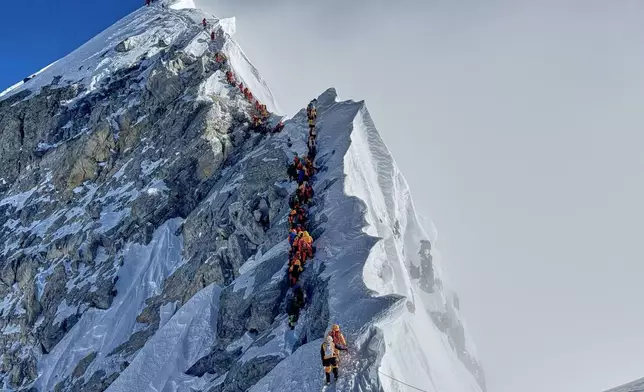 FILE - Mountaineers form a queue as they approach the summit of Mount Everest in Nepal, May 18, 2025. (AP Photo/Kunga Sherpa, File)