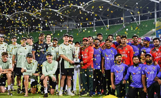 Bangladesh and New Zealand players pose with the trophy after having drawn the series of T20 international cricket match in Mirpur, Bangladesh, Saturday, May 2, 2026. (AP Photo/Mosaraf Hossain)