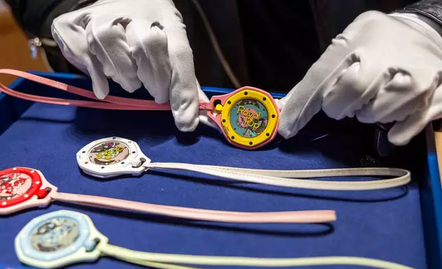 A saleswoman shows the new Royal Pop watch by Swatch and Audemars Piguet, in Geneva, Switzerland, Saturday, May 16, 2026. (Salvatore Di Nolfi/Keystone via AP)