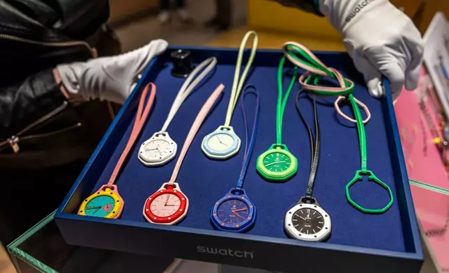 A saleswoman shows the new Royal Pop watches by Swatch and Audemars Piguet, in Geneva, Switzerland, Saturday, May 16, 2026. (Salvatore Di Nolfi/Keystone via AP)