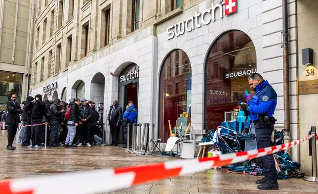 Swiss police officers secure the area where customers queue to buy the new Royal Pop watch by Swatch and Audemars Piguet, in Geneva, Switzerland, Saturday, May 16, 2026. (Salvatore Di Nolfi/Keystone via AP)