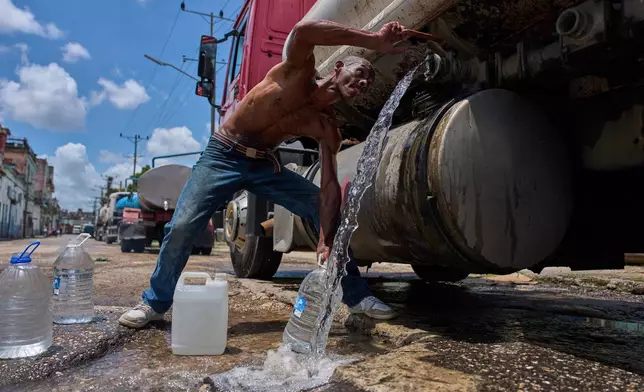 A man fills water jugs from a tanker truck in Havana, Thursday, May 28, 2026. (AP Photo/Ramon Espinosa)
