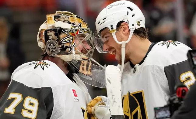 Vegas Golden Knights goaltender Carter Hart, left, and center Brett Howden congratulate each other after the Golden Knights defeated the Anaheim Ducks in Game 6 of a second-round NHL hockey Stanley Cup playoff series Thursday, May 14, 2026, in Anaheim, Calif. (AP Photo/Mark J. Terrill)