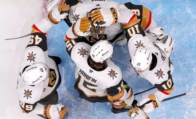 Vegas Golden Knights goaltender Carter Hart, top, is congratulated by teammates after the Golden Knights defeated the Anaheim Ducks in Game 6 of a second-round NHL hockey Stanley Cup playoff series Thursday, May 14, 2026, in Anaheim, Calif. (AP Photo/Mark J. Terrill)