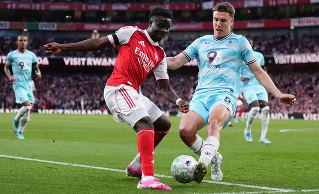 Arsenal's Bukayo Saka, left, and Burnley's Maxime Esteve battle for the ball during the English Premier League soccer match between Arsenal and Burnley in London, Monday May 18, 2026. (John Walton/PA via AP)