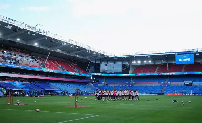 Lyonnes players and staff gather together on the pitch during a training session on the eve of the Women's Champions League final soccer match between FC Barcelona and OL Lyonnes, in Oslo, Friday, May 22, 2026. (AP Photo/Kirsty Wigglesworth)