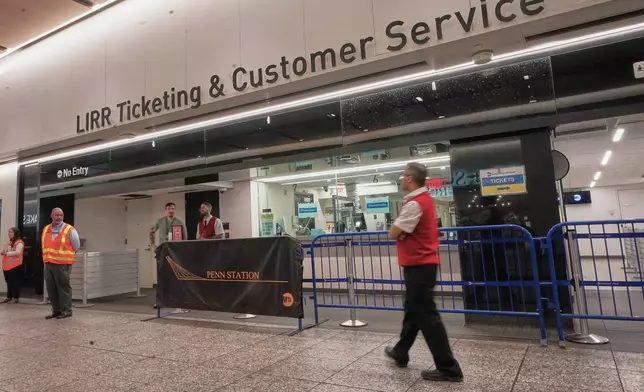 Workers stand near the Long Island Raill Road ticketing counter in New York's Penn Station, Tuesday, May 19, 2026. (AP Photo/Richard Drew)