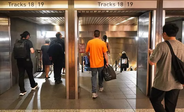 Passengers walk to Long Island Rail Road trains in Pennsylvania Station, in New York, Tuesday, May 19, 2026. (AP Photo/Richard Drew)