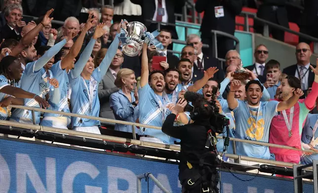 Manchester City players celebrate with the winner's trophy after the English FA Cup final soccer match between Chelsea and Manchester City in London, Saturday, May 16, 2026. (AP Photo/Richard Pelham)