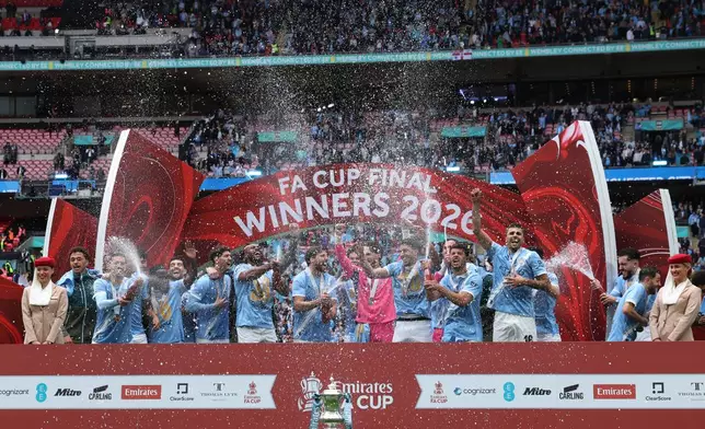 Manchester City players celebrate with the winner's trophy after the English FA Cup final soccer match between Chelsea and Manchester City in London, Saturday, May 16, 2026. (AP Photo/Richard Pelham)