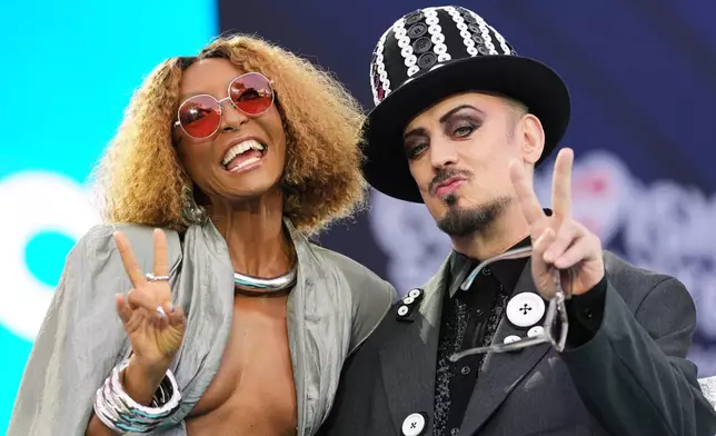 Artist Senhit from San Marino and British pop star Boy George react to fans on the signature turquoise carpet during the official start of the Eurovision Song Contest week at the town hall in Vienna, Austria, Sunday, May 10, 2026. (AP Photo/Martin Meissner)