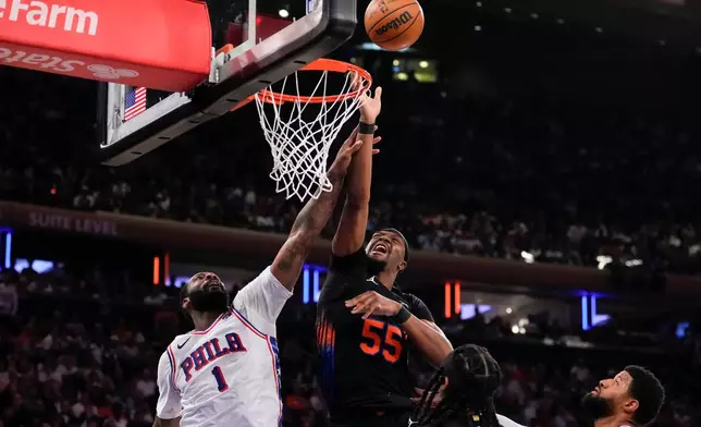 New York Knicks center Ariel Hukporti (55) fights for control of the ball with Philadelphia 76ers center Andre Drummond (1) during the first half of Game 2 in a second-round NBA basketball playoffs series, Wednesday, May 6, 2026, in New York. (AP Photo/Yuki Iwamura)