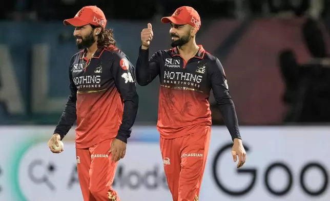 Royal Challengers Bengaluru's captain Rajat Patidar, left, celebrates with teammate Virat Kohli after taking the catch to dismiss Gujarat Titans' Rahul Tewatia during the Indian Premier League cricket match between Gujarat Titans and Royal Challengers Bengaluru in Dharamshala, India, Tuesday, May 26, 2026. (AP Photo/Ashwini Bhatia)