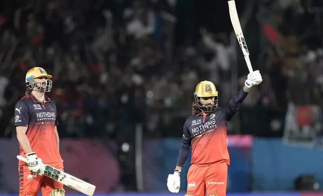 Royal Challengers Bengaluru's captain Rajat Patidar, right, celebrates his fifty runs during the Indian Premier League cricket match between Gujarat Titans and Royal Challengers Bengaluru in Dharamshala, India, Tuesday, May 26, 2026. (AP Photo/Ashwini Bhatia)