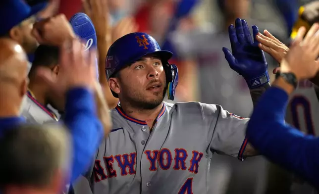 New York Mets catcher Francisco Alvarez is congratulated by teammates in the dugout after Marcus Semien hit a two RBI single during the sixth inning of a baseball game Friday, May 1, 2026, in Anaheim, Calif. (AP Photo/Mark J. Terrill)