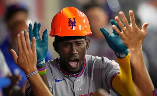 New York Mets' Ronny Mauricio is congratulated by teammates in the dugout after hitting a solo home run during the seventh inning of a baseball game against the Los Angeles Angels, Friday, May 1, 2026, in Anaheim, Calif. (AP Photo/Mark J. Terrill)