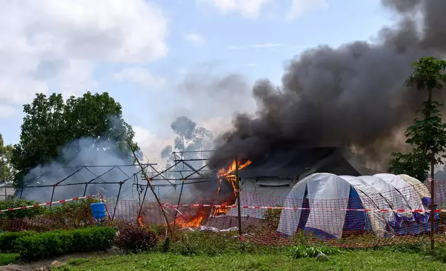 Flames and smoke rise from an Ebola treatment center in Rwampara, Congo, Thursday, May 21, 2026. (AP Photo/Dirole Lotsima Dieudonne)