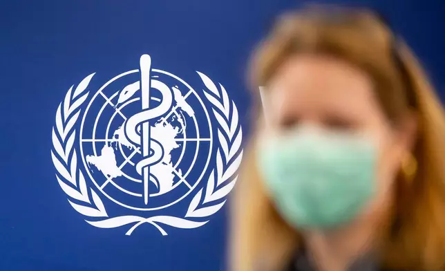 A person is wearing a protective face mask in front of the WHO logo, during the media regarding the epidemic of Ebola disease, during a press conference at the World Health Organization (WHO) headquarters in Geneva, Switzerland, Friday, May 22, 2026. (Martial Trezzini/Keystone via AP)