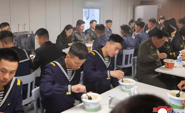 In this photo provided on May 8, 2026, by the North Korean government, its leader Kim Jong Un, rear center, and his daughter have meal with sailors on the destroyer Choe Hyon off North Korea's west coast, Thursday, May 7, 2026. Independent journalists were not given access to cover the event depicted in this image distributed by the North Korean government. The content of this image is as provided and cannot be independently verified. Korean language watermark on image as provided by source reads: "KCNA" which is the abbreviation for Korean Central News Agency. (Korean Central News Agency/Korea News Service via AP)