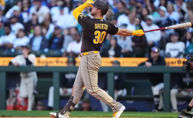 San Diego Padres' Gavin Sheets follows through on a two-run home run against the Seattle Mariners during the sixth inning of a baseball game, Sunday, May 17, 2026, in Seattle. (AP Photo/Lindsey Wasson)
