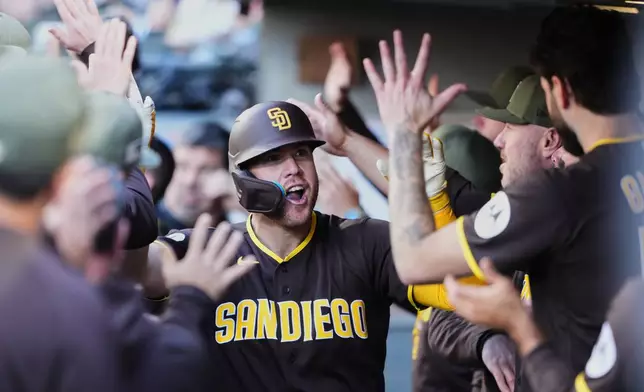San Diego Padres' Gavin Sheets celebrates in the dugout after hitting a two-run home run against the Seattle Mariners during the sixth inning of a baseball game, Sunday, May 17, 2026, in Seattle. (AP Photo/Lindsey Wasson)