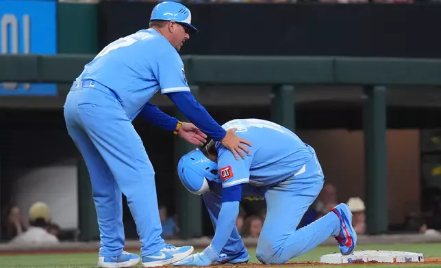 Kansas City Royals' Maikel Garcia, right, is aided by third base coach Vance Wilson, left, after he was injured during the seventh inning of a baseball game against the Texas Rangers, Saturday, May 30, 2026, in Arlington, Texas. (AP Photo/LM Otero)