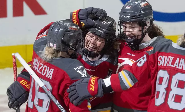 Ottawa Charge forward Fanuza Kadirova (71) celebrates after her goal with forwards Katerina Mrazova (16) and Sarah Wozniewicz (23) during the first period of Game 4 in a PWHL hockey playoff series against the Bosotn Fleet in Ottawa, Ontario, Sunday, May 10, 2026. (Adrian Wyld/The Canadian Press via AP)