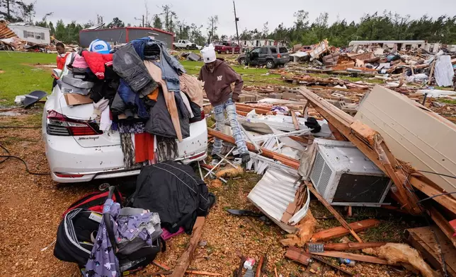 A person stands among debris at Gene's Mobile Home Supply, a trailer park in Bogue Chitto, Miss., Thursday, May, 7, 2026, after a tornado cut across the state. (AP Photo/Gerald Herbert)