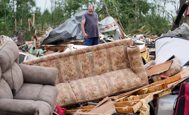 A man stands among debris at Gene's Mobile Home Supply, a trailer park in Bogue Chitto, Miss., Thursday, May, 7, 2026, after a tornado cut across the state. (AP Photo/Gerald Herbert)