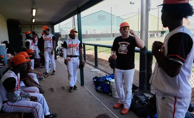 McClymonds High School head coach Jamey Smart, center, talks with his team inside the dugout during the third inning of a baseball game against Skyline High School in Oakland, Calif., Friday, May 1, 2026. (AP Photo/Godofredo A. Vásquez)