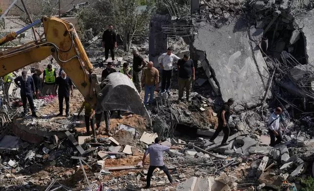 Rescue workers search for survivors using heavy machinery in the rubble of houses damaged by an Israeli airstrike in the village of Saksakieh, south Lebanon, Saturday, May 9, 2026. (AP Photo/Mohammed Zaatari)