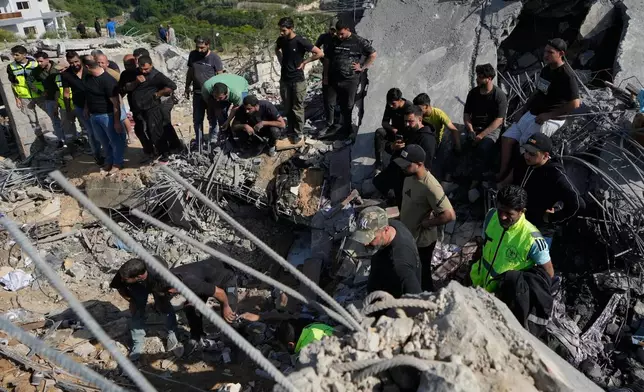 Residents gather as others search through the rubble of houses damaged by an Israeli airstrike in the village of Saksakieh, southern Lebanon, Saturday, May 9, 2026. (AP Photo/Mohammed Zaatari)