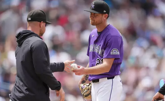 Colorado Rockies manager Warren Schaeffer, left, takes the ball from starting pitcher Kyle Freeland as he is pulled from the mound after issuing a bases-loaded walk to Atlanta Braves' Eli White in the fifth inning of a baseball game, Sunday, May 3, 2026, in Denver. (AP Photo/David Zalubowski)