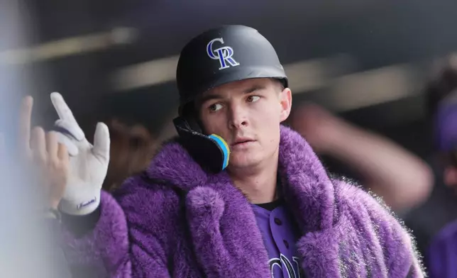 Colorado Rockies' Mickey Moniak is congratulated as he returns to the dugout after hitting a two-run home run off Atlanta Braves relief pitcher Aaron Bummer in the fourth inning of a baseball game, Sunday, May 3, 2026, in Denver. (AP Photo/David Zalubowski)