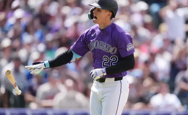 Colorado Rockies' Mickey Moniak tosses his bat as he heads up the first-base line after hitting a two-run home run off Atlanta Braves relief pitcher Aaron Bummer in the fourth inning of a baseball game, Sunday, May 3, 2026, in Denver. (AP Photo/David Zalubowski)