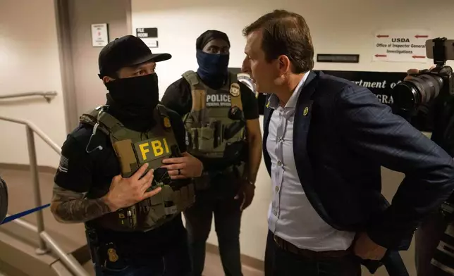FILE - Rep. Dan Goldman, D-N.Y., left, speaks to the federal agents at the Jacob K. Javits federal building, June 18, 2025, in New York. (AP Photo/Yuki Iwamura, File)