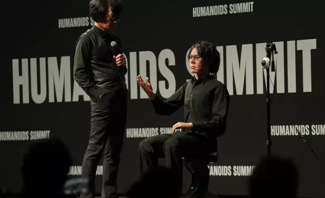 Professor Hiroshi Ishiguro of Osaka University talks to android robot Geminoid at the Humanoids Summit 2026 in Tokyo, Thursday, May 28, 2026. (AP Photo/Ayaka McGill)