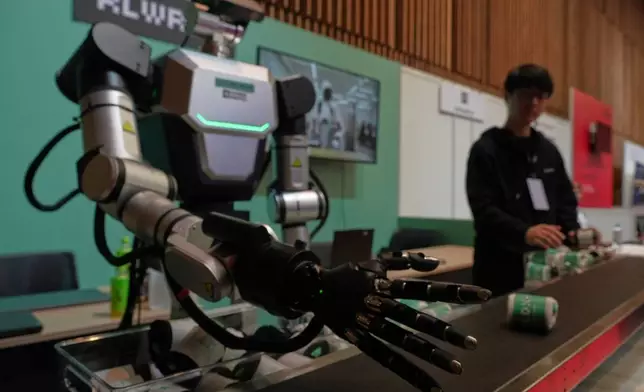 A robot demonstrates picking up a pair of socks at the Humanoids Summit 2026 in Tokyo, Thursday, May 28, 2026. (AP Photo/Ayaka McGill)