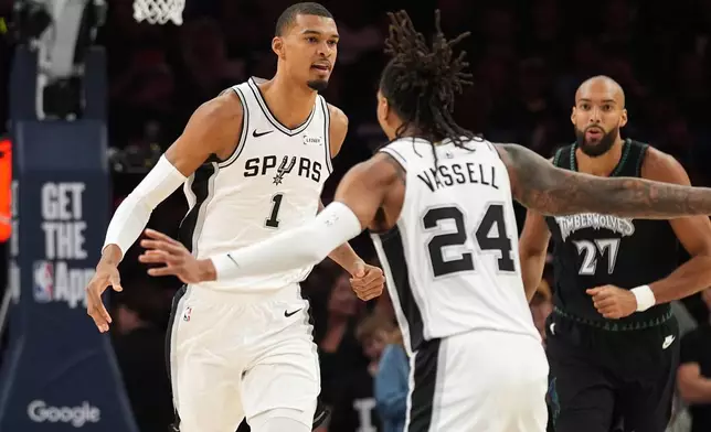 San Antonio Spurs forward Victor Wembanyama (1) celebrates a score against the Minnesota Timberwolves with teammate guard Devin Vassell (24) during the first half of Game 3 of a NBA basketball second-round playoff series in Minneapolis, Friday, May 8, 2026. (AP Photo/Abbie Parr)