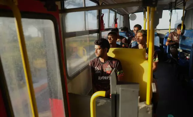 Players of Originarios, a new soccer team in Rio's fifth division made up exclusively of Indigenous players, ride a bus to practice in Marica, Brazil, Tuesday, April 28, 2026. (AP Photo/Silvia Izquierdo)