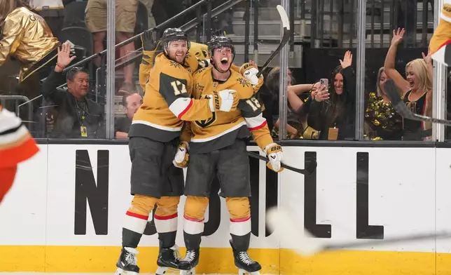 Vegas Golden Knights right wing Pavel Dorofeyev (16) celebrates his game-winning goal with defenseman Ben Hutton (17) during overtime of Game 5 of a second-round NHL hockey Stanley Cup playoff series against the Anaheim Ducks Tuesday, May 12, 2026, in Las Vegas. (AP Photo/Candice Ward)