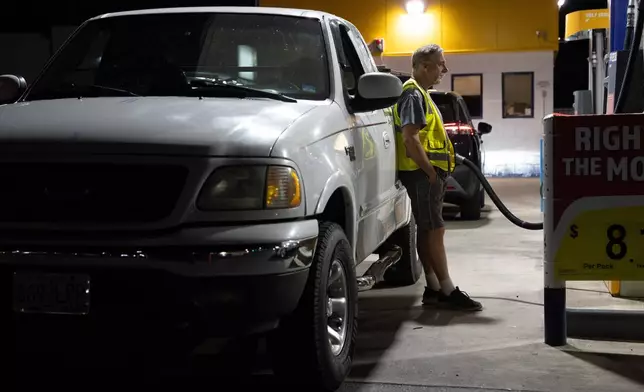 A person waits while filling their fuel tank at an Astro gas station on Wednesday, April 29, 2026, in Portland, Ore. (AP Photo/Jenny Kane)