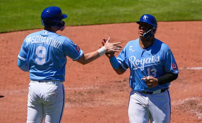 Kansas City Royals' Salvador Perez (13) celebrates with Vinnie Pasquantino (9) after they both scored on a two-run double hit by Carter Jensen during the fifth inning of a baseball game against the Seattle Mariners, Sunday, May 24, 2026, in Kansas City, Mo. (AP Photo/Charlie Riedel)