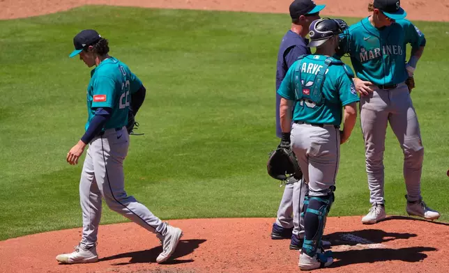 Seattle Mariners starting pitcher Bryan Woo walks to the dugout during a pitching change in the fifth inning of a baseball game against the Kansas City Royals, Sunday, May 24, 2026, in Kansas City, Mo. (AP Photo/Charlie Riedel)