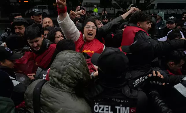 Union members scuffle with Turkish police officers as they try to march towards Taksim square in Istanbul, Turkey, Friday, May 1, 2026, during Labor Day celebrations. (AP Photo/Khalil Hamra)