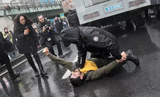 An union member is detained by a Turkish police officer as people try to march towards Taksim square in Istanbul, Turkey, Friday, May 1, 2026, during Labor Day celebrations. (AP Photo/Khalil Hamra)