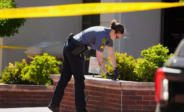 A Sheriff's deputy investigates a shooting scene outside the Montgomery County Courthouse, Wednesday, May 13, 2026, in Clarksville, Tenn. (AP Photo/George Walker IV)